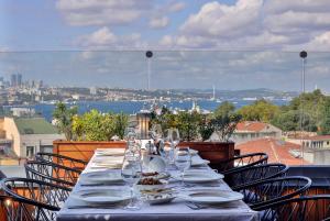 a table with plates and wine glasses on a balcony at Orient Express & Spa by Orka Hotels in Istanbul