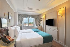 a hotel room with a large bed and a window at Orient Express & Spa by Orka Hotels in Istanbul