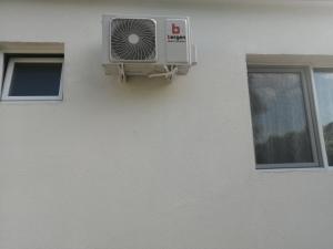 un climatiseur sur le côté du bâtiment dans l'établissement Family hоuse, à Banja Koviljača