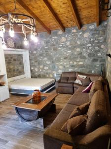 a living room with a couch and a table at House with big garden and barbeque in nature in Potamiá