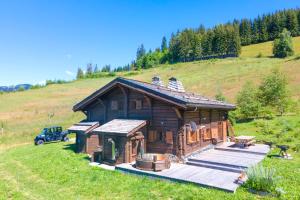 a log cabin on a hill in a field at IMMOBILIER DE MONTAGNE - LA COLLECTION - L'alpage in Saint-Gervais-les-Bains