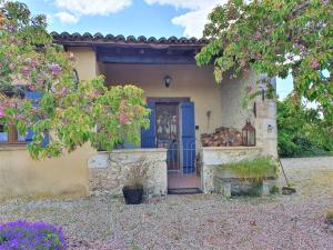 a house with a blue door and a tree at La Petite Auberge - Gîtes in Razac-dʼEymet