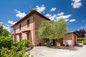 an old brick house with a tree in front of it at Agriturismo Podere Camollia in Costalpino