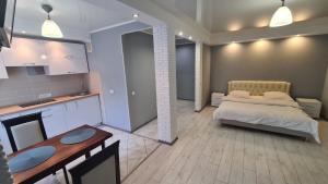 a bedroom with a bed and a kitchen with a table at Apartaments on vulytsia Heroiv Ato 32 (97th Kvartal) in Kryvyi Rih