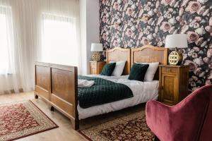 a bedroom with a bed and a floral wall at Żółty Rower in Tleń