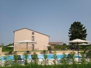 una piscina con sillas y sombrillas frente a un edificio en agriturismo Casa Pezzo, en Castelnuovo del Garda