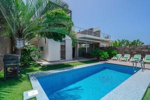 a villa with a swimming pool and a house at Lux Villa 31 in Adeje