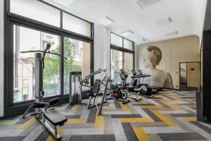 a gym with treadmills and a statue in the background at Emerald Downtown Luxury Suites with Hotel services in Budapest