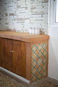 a wooden cabinet in a room with a brick wall at Preciosa y confortable casa de campo con piscina y chimenea in Carmona