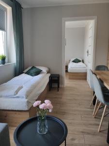 um quarto com duas camas e uma mesa com flores em Krollhouse Pokoje gościnne em Wolbrom