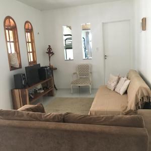 een woonkamer met een bank en een tv bij CASA POR TEMPORADA NA SERRA in Ibiapina
