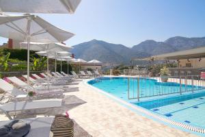 una piscina con tumbonas y sombrillas junto a una piscina en Amalia Apartments, en Balíon