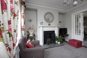 a living room with a chair and a fireplace at Willoughby Place in Enniskillen