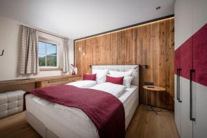 a bedroom with a large bed with a wooden wall at Luxury Apartments "R6 Tegernsee" in Bad Wiessee