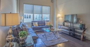 a living room with a couch and a tv at 2 Bedroom Fully Furnished Apartment near Emory University Hospital Midtown in Atlanta