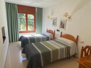 
a bedroom with a bed, chair and a window at Hotel Puitavaca in Vall de Cardos
