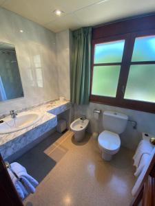 
a bathroom with a toilet a sink and a bathtub at Hotel Puitavaca in Vall de Cardos
