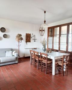 sala de estar con mesa blanca y sillas en La Masseria Casa Vacanze, en Empoli