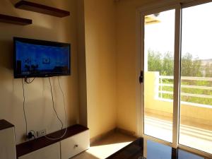 a living room with a tv and a sliding glass door at Hurghada Comfort Apartments in Hurghada