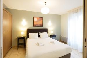 a bedroom with a bed with two towels on it at Residhotel Toulouse Centre in Toulouse