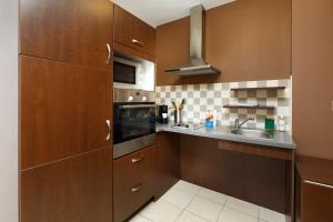 a kitchen with wooden cabinets and a sink at Residhotel Toulouse Centre in Toulouse