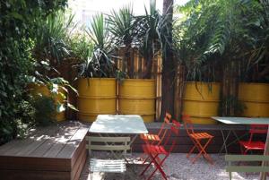 eine Terrasse mit Tischen, Stühlen und Topfpflanzen in der Unterkunft Logies Lapin in Antwerpen