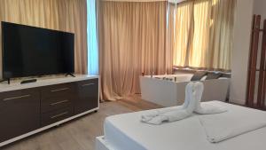 um quarto de hotel com uma cama e uma televisão de ecrã plano em Star Hotel em Tirana