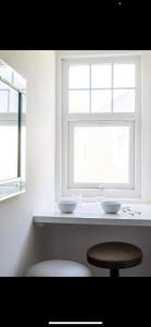 una cocina blanca con 2 lavabos y una ventana en Driftwood Luxury Apartment, en Lyme Regis