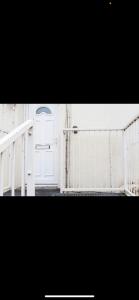 una puerta blanca abierta con una puerta blanca en Driftwood Luxury Apartment, en Lyme Regis