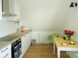 a kitchen with a table and a small table with flowers at FeWo am Deister in Bad Münder am Deister