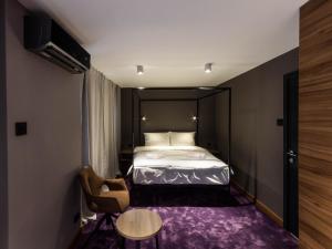 a bedroom with a bed and a table and a chair at Elite Space in Niš