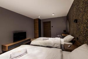 a hotel room with two beds and a flat screen tv at Elite Space in Niš