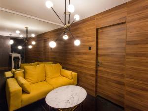 a living room with a yellow couch and a table at Elite Space in Niš