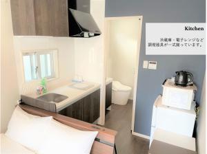 a small bathroom with a sink and a microwave at T&T Villa 宮古島 in Miyako-jima