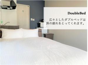 a bedroom with a white bed and a sign at T&T Villa 宮古島 in Miyako-jima