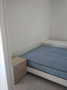 ein kleines Schlafzimmer mit einem Bett und einem Holzschrank in der Unterkunft Casa vacanze in Bianco