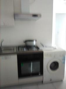 eine Küche mit einem Herd und einer Waschmaschine in der Unterkunft Casa vacanze in Bianco