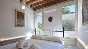 a bedroom with a bed and two windows at Corte dei Greci in Venice