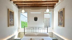 a bedroom with a bed in a room with two windows at Corte dei Greci in Venice