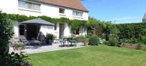 Lasnelittle cottage的后院配有桌椅和遮阳伞