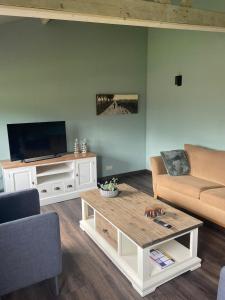 uma sala de estar com um sofá e uma mesa de centro em De Dennen em Odoorn