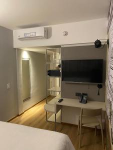 a kitchen with a table and a television at ibis Styles Buenos Aires Florida in Buenos Aires