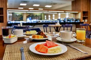 a table with plates of food and cups of orange juice at Days Inn by Wyndham Rio de Janeiro Lapa in Rio de Janeiro