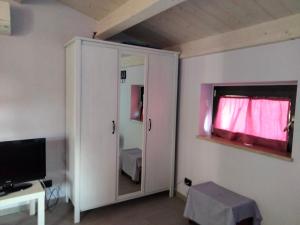 a room with a cabinet with a mirror and a television at Residenza Flores in Pescara