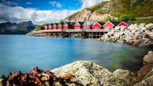 a row of houses on a dock in the water at Lofoten Rorbu Lodge in Offersøya +41 photos