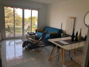 sala de estar con sofá azul y mesa en Le Beauvallon, en Antibes