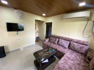a living room with a couch and a tv at Farmhouse in Pune city in Pune