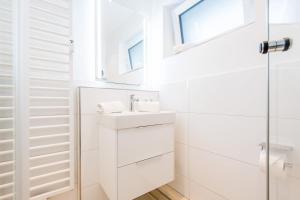 a white bathroom with a sink and a mirror at Haus Christianenhoehe Whg 10 in Westerland (Sylt) +29 photos