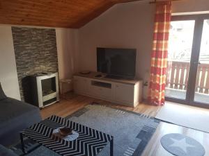 sala de estar con TV de pantalla plana y sofá en Ferienwohnung Dressler, en Pfronten