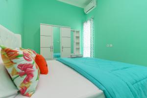 茂物的住宿－KoolKost @ Ikost Cimahpar Indah，蓝色的卧室设有床和窗户